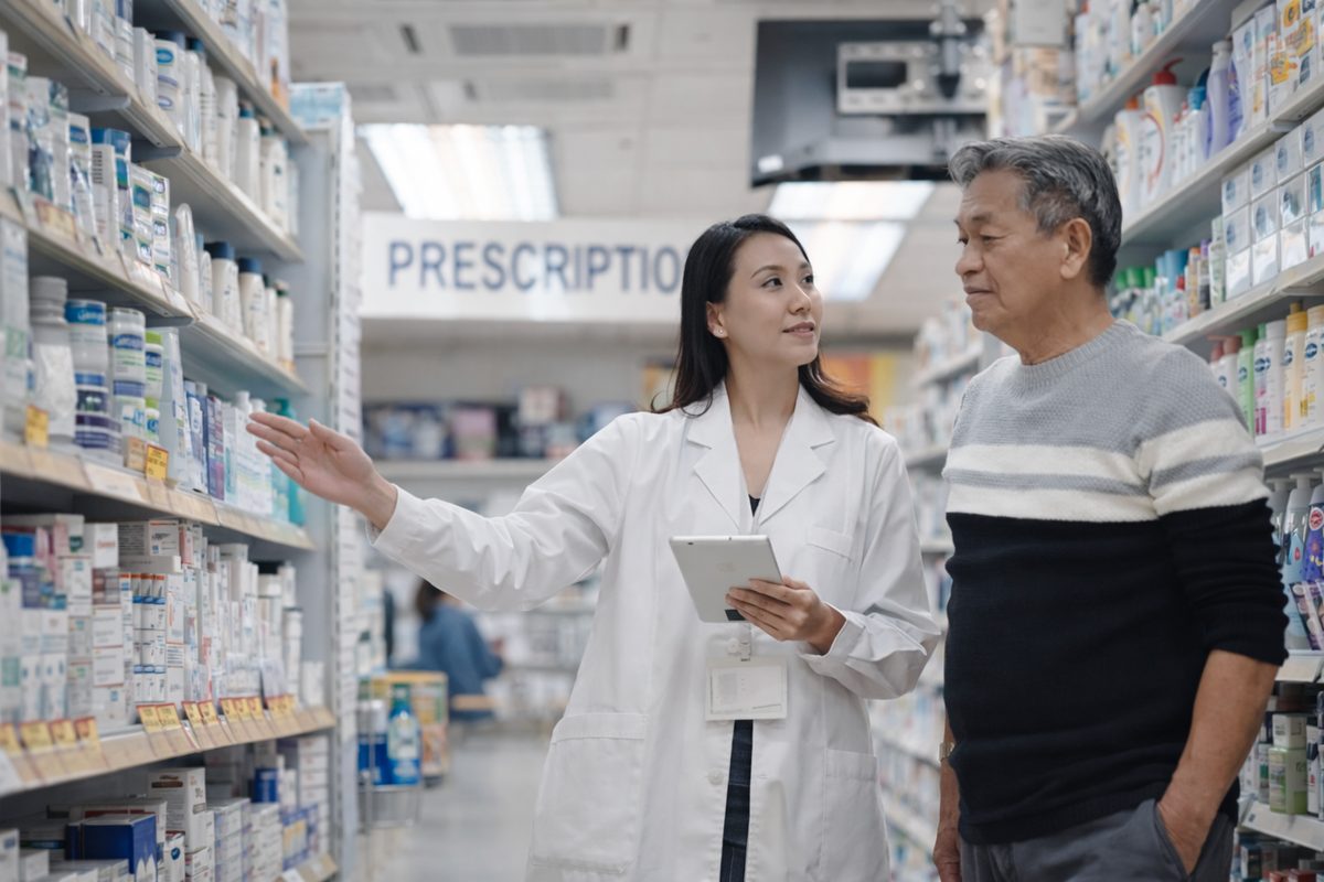 Pharmacist guiding a patient in the prescription aisle